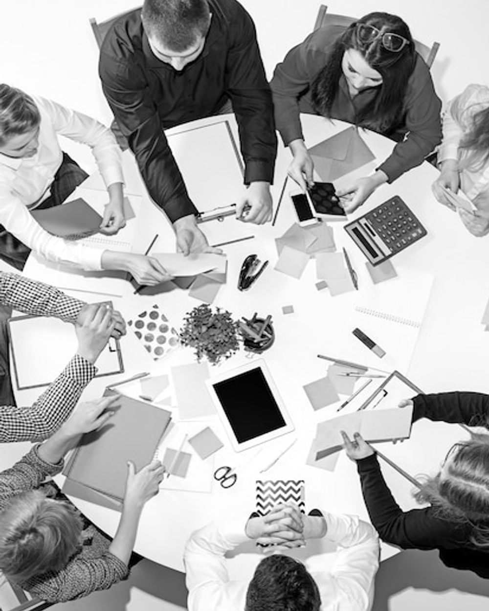 Equipo de trabajo revisando materiales alrededor de una mesa